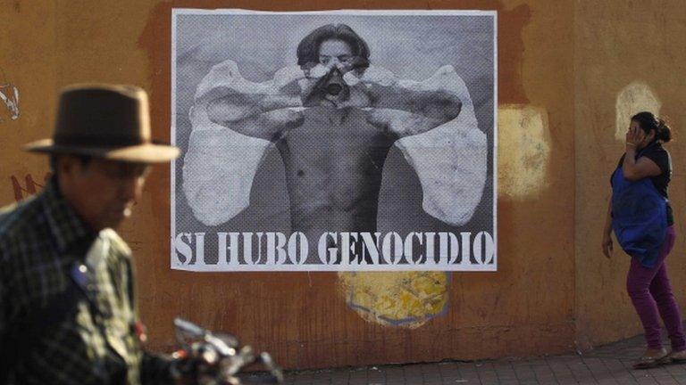 Guatemalans pass a poster reading: "Yes, there was a genocide" in Guatemala City on 15 May 2013