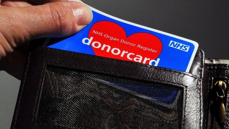 A donor card being taken out of a wallet