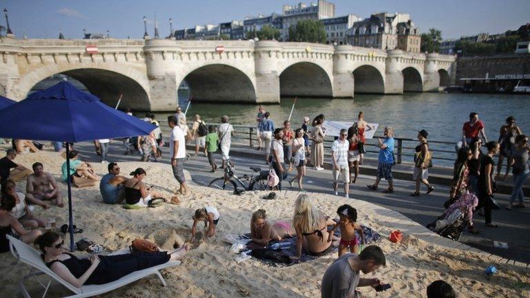 People relax on a temporary urban beach in Paris, near the Pont Neuf bridge, 20 July