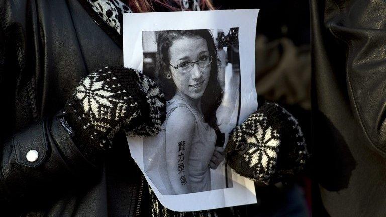 Woman holds a picture of Rehtaeh Parsons in Halifax, Nova Scotia on 11 April 2013