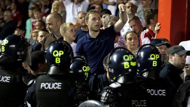 Bristol City fans are kept away from Bristol Rovers fans by police using riot gear