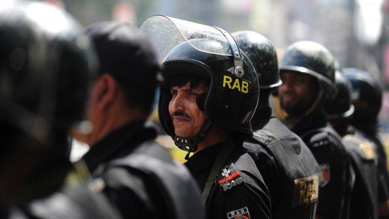 Bangladeshi Rapid Action Battalion (RAB) personnel stand guard during a nationwide strike in Dhaka on 18 September 2013