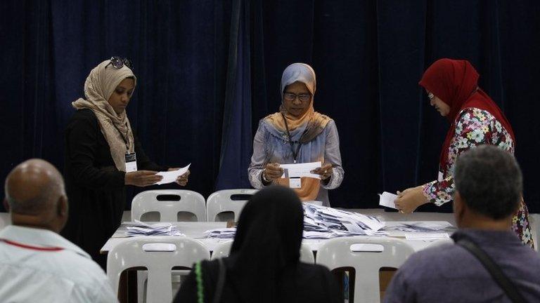 Officers at a counting centre count ballot papers in front of election monitors during presidential elections in Male, 7 September 2013