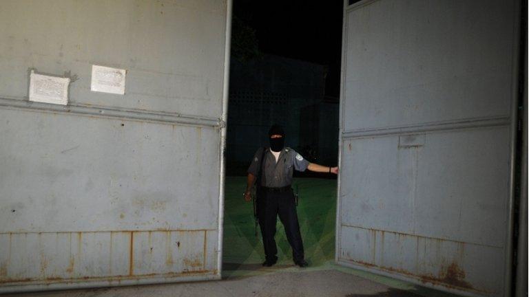 A prison warden secures a gate at the prison in Tonacatepeque on 24 September 2013