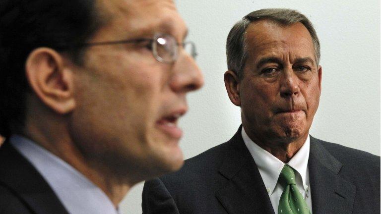 US House Speaker John Boehner listens to colleague Eric Cantor speak to the press after a House Republican meeting on Capitol Hill 26 September 2013