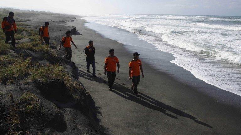 Rescue workers walk along the beach as they search for suspected asylum seekers, who were on a boat that capsized late on Tuesday, after hitting a reef off the coast of Sukapura, at Sukapura beach, Cidaun district of Cianjur, Indonesia West Java province 25 July, 2013.