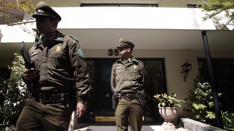 Officer stands guard outside the house Odlanier Mena killed himself