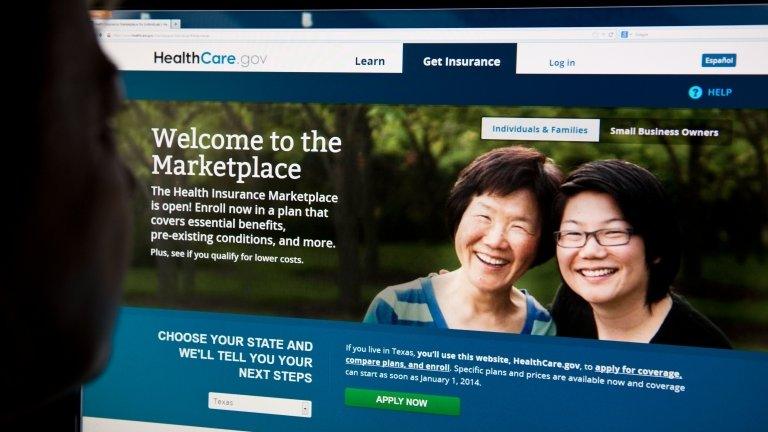 A woman looks at the HealthCare.gov website on 1 October 2013