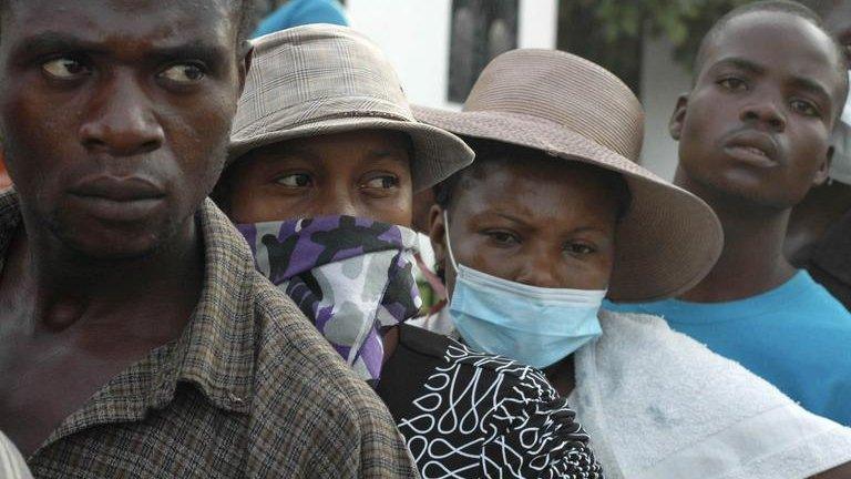 Relatives of Haitians suffering from cholera wait for news outside a local hospital in the town of Saint Marc on 22 October, 2010