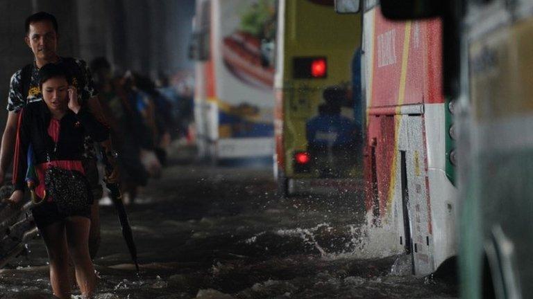 Woman on mobile phone during Manila floods in August 2013