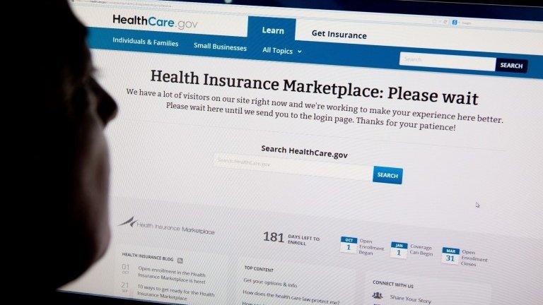 A woman looks at the HealthCare.gov insurance exchange internet site showing a "Please wait" page, in this 1 October 2013 file photo in Washington, DC