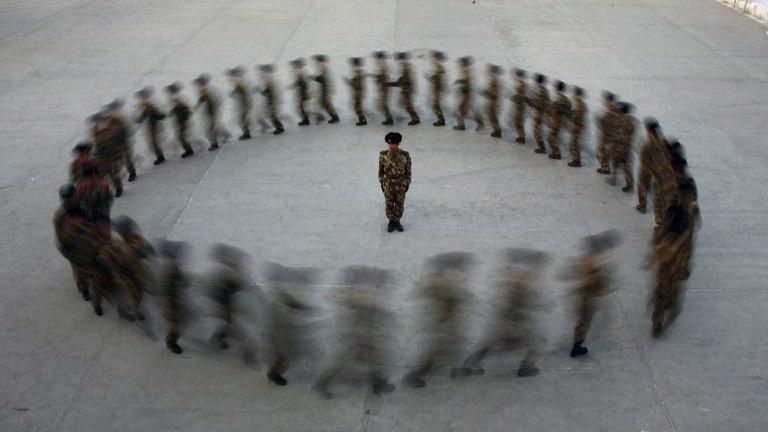 Commander watches paramilitary police recruits run in a circle during training, Xinjiang (file photo - 28 August)