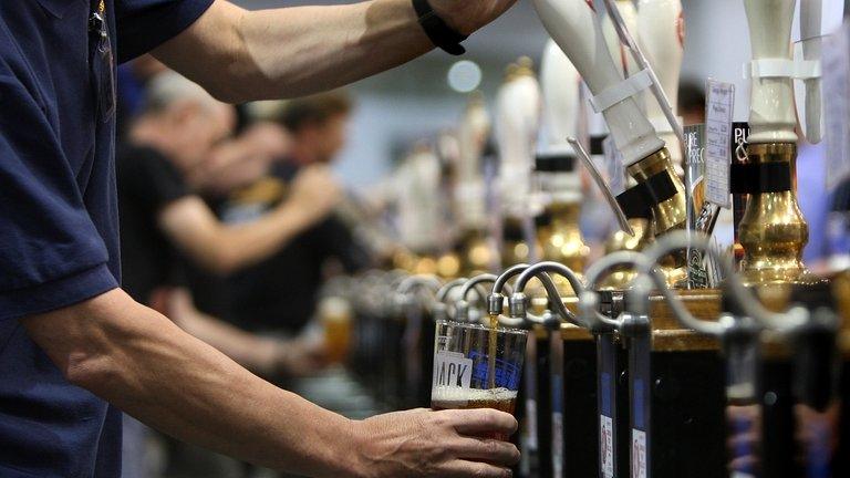 Barmen pull pints of beer