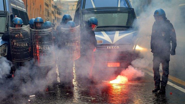 A policeman clears away a flare during a confrontation with students in Rome, 15 November