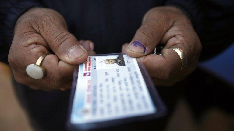 A Nepalese voter displays his voter identity card after casting his vote at a polling station in Bhaktapur, Nepal, Tuesday, Nov. 19, 2013.