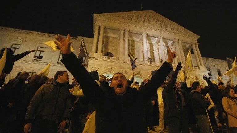 A demonstrator shouts after breaking through a line of policemen guarding the Portuguese parliament in Lisbon 21 November.