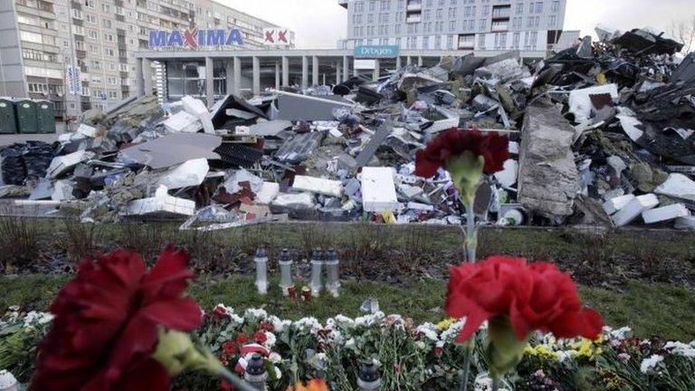 Flowers in front of the collapsed Maxima store in Riga, 26 Nov