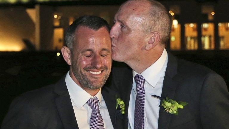 Western Australian politician Stephen Dawson, right, gives his husband Dennis Liddelow a kiss after they married in front of Parliament House in Canberra, Australia, Saturday, Dec. 7, 2013