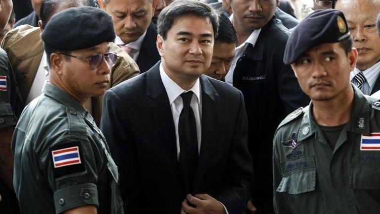 Democrat Party leader and former prime minister Abhisit Vejjajiva (centre) arrives at Bangkok criminal court in Bangkok, 12 December 2013