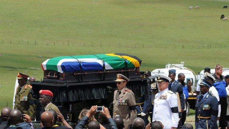 Nelson Mandela's coffin is taken to his final resting place in Qunu by a military guard of honour