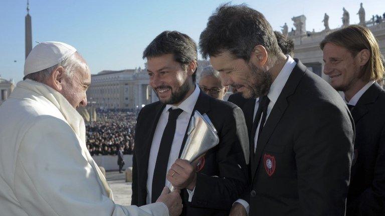 Members of Argentine soccer present Pope Francis with a replica of the Argentine soccer championship trophy on 18 December, 2013