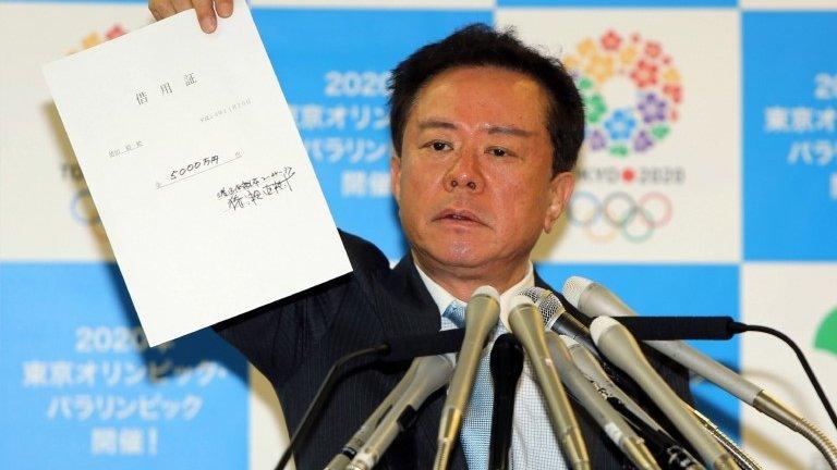 File photo: Tokyo Governor Naoki Inose shows the $500,000 IOU during a press conference at the Tokyo metropolitan government office on 26 November 2013