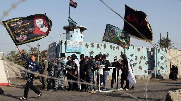 Iraqi police check pilgrims in the Dora district of Baghdad (19 December 2013)