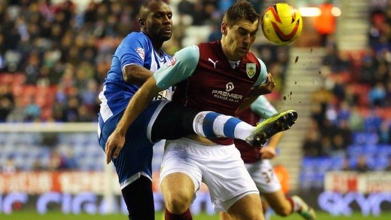 Wigan Athletic's Emerson Boyce challenges Burnley's Sam Vokes