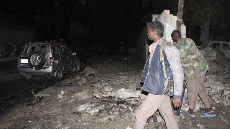 Police officers assess the scene of an explosion outside the Jazeera