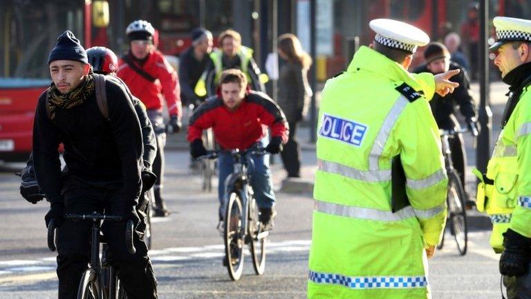 Police officers watch cyclists during Operation Safeway in November