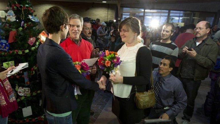 Natalie Dicou, left, and Nicole Christensen, right, are married by Salt Lake City Mayor Ralph Becker, middle, in the lobby of the Salt Lake County Clerk's Office in Salt Lake City 20 December 2013