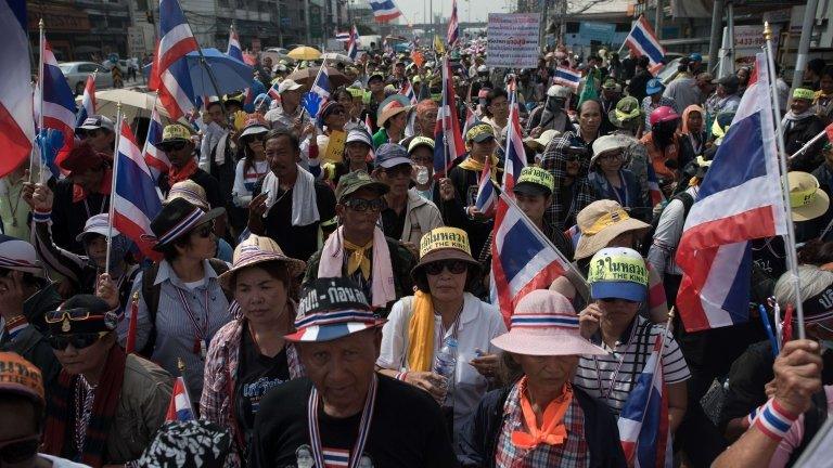 Thai anti-government protesters wave national flags during a rally in Bangkok on 7 January 2014