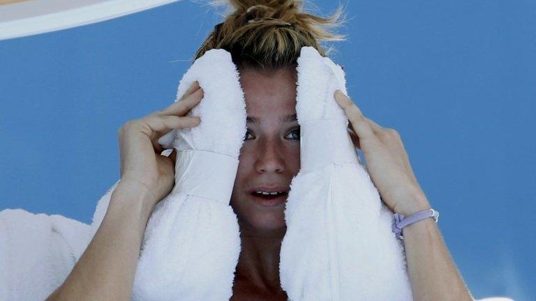 Camila Giorgi of Italy holds an ice towel to her face during her women's singles match against Alize Cornet of France at the Australian Open 2014 tennis tournament in Melbourne, 16 January 2014