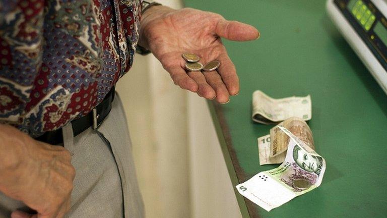 a man searches for coins in his pocket to buy groceries in Buenos Aires, Argentina (file photo)