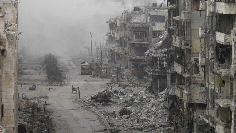 Smoke rises from buildings after what activists said was shelling from forces loyal to Syria's President Bashar al-Assad in the besieged area of Homs on 15 January 2014