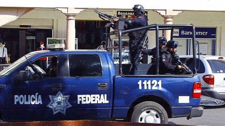 Mexican federal police patrol the streets of Apatzingan, Michoacan State, Mexico (18 January)