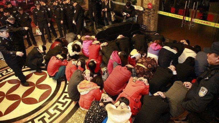 Chinese police round up alleged sex workers and clients at an entertainment centre in Dongguan, southern China's Guangdong province, 9 February 2014