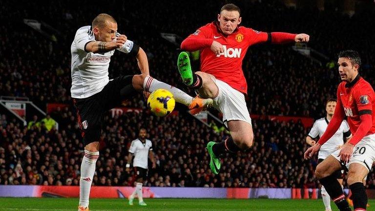 Manchester United forward Wayne Rooney (2L) vies with Fulham's Dutch defender John Heitinga the match between Manchester United and Fulham