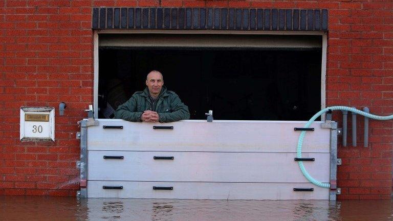 Resident looks out from his flood-hit garage