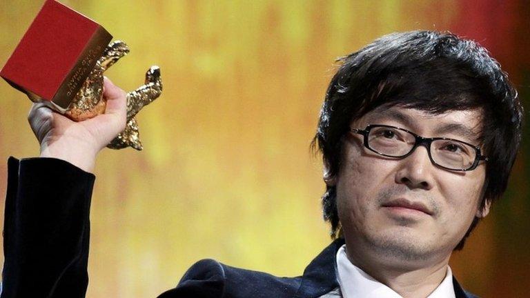 Chinese director Diao Yinan holds up the Golden Bear trophy for Best Film during the awards ceremony of the 64th Berlinale International Film Festival in Berlin