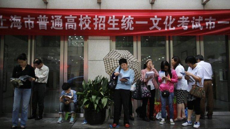 Parents wait outside Shanghai No.1 High School for their children to finish the first part of the "gaokao", China's annual national college entrance exam in Shanghai June 7, 2013