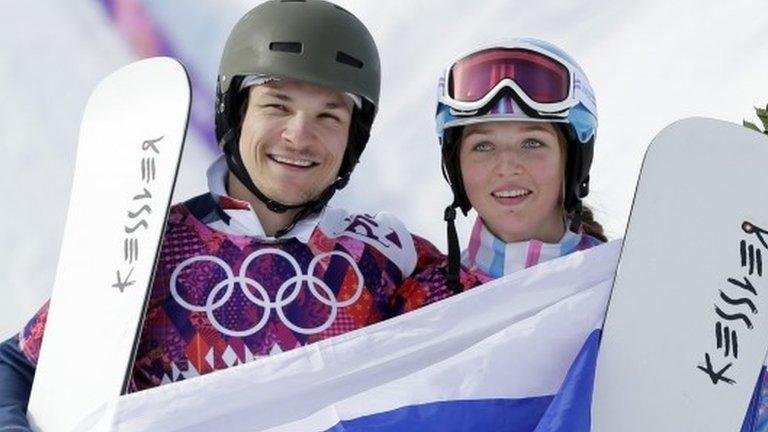 Russia's Vic Wild, left, poses after winning the gold medal in the men's snowboard parallel giant slalom final, with his wife and bronze medalist in the women's snowboard parallel giant slalom final, Russia's Alena Zavarzina