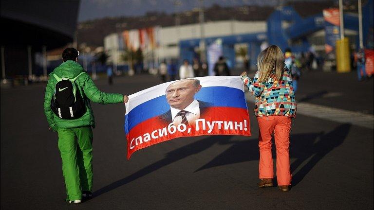 Veleriya Obarevich, right, and Yan Shamilov carry a Russian flag with the message "Thank you, Putin!"