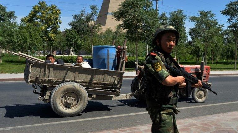 File photo of a Chinese paramilitary police man a checkpoint on the road to the riot-affected Uighur town of Lukqun, Xinjiang province