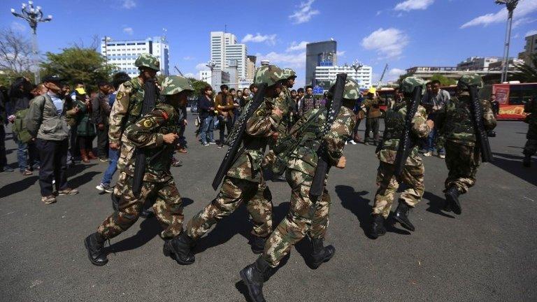 Paramilitary policemen run as they patrol along a street after a knife attack near Kunming railway station in Kunming, Yunnan province March 3, 2014.