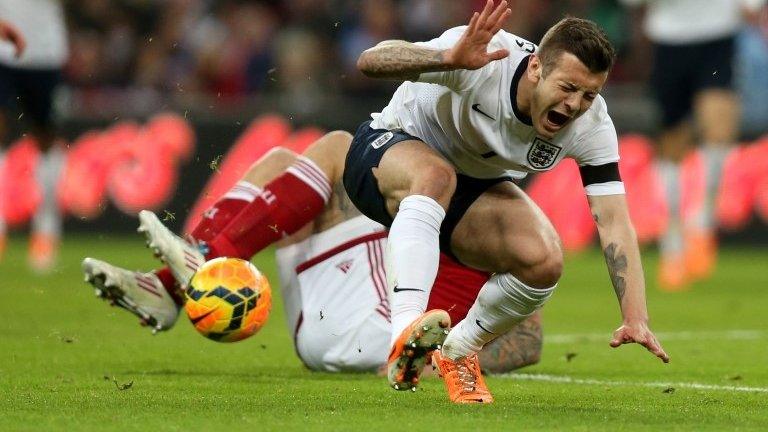 Jack Wilshere is hurt in a tackle by Daniel Agger