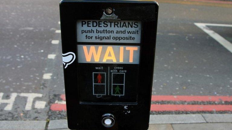 An illuminated WAIT signal at a pedestrian crossing