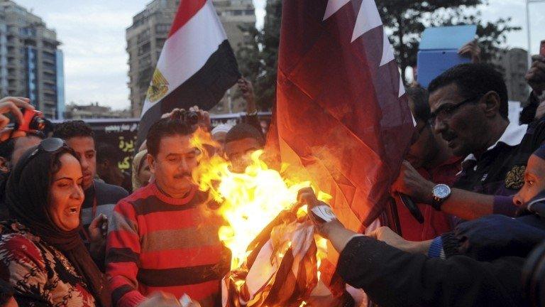 Egyptians burn the Qatar's flag outside its embassy in Cairo (30 November 2013)