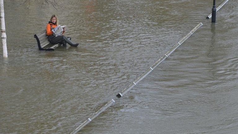 Woman sitting in floodwater in Staines