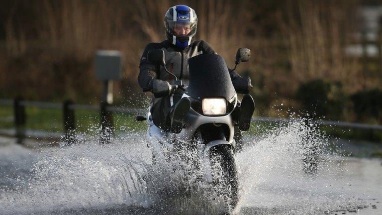 Motorcyclist riding through floodwater in Chertsey